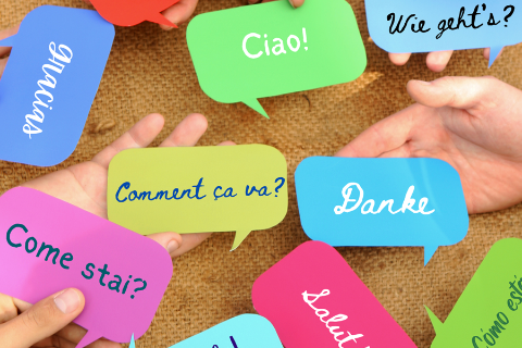 Hands holding speech bubbles with hello written in different languages